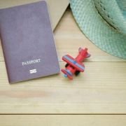 Titolo viaggiare e conoscere immagine di passaporto, modellino aereo e cappello su un tavolo